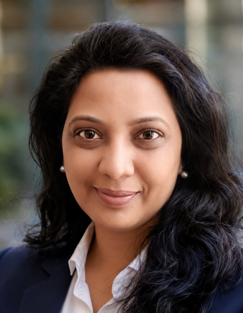 Naga Vasundhara Machani, in a navy jacket and white shirt, photographed outdoors